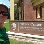 Rich Houston, history teacher in front of National Park Visitor Center sign